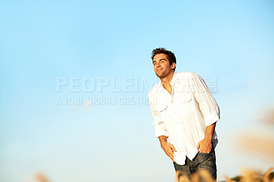 Buy stock photo Relax, walking or happy man with blue sky in nature for outdoor weekend, stress relief or fresh air. Calm, male person or breathing with smile for comfort, holiday or travel on space in countryside