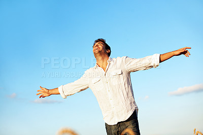 Buy stock photo Freedom, happy and man in field with blue sky, gratitude and open arms for peace on weekend. Countryside, smile and person with space, thinking and reflection for holiday, break and relax outdoor