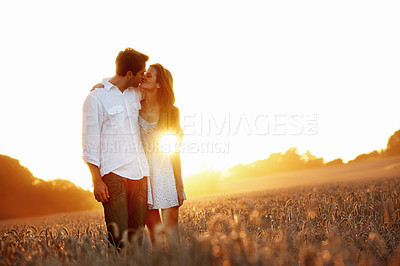 Buy stock photo Travel, sunset and couple with kiss in field for romantic getaway, holiday connection or trust. Sunshine, people or affection in countryside for anniversary trip, bonding or healthy marriage on space