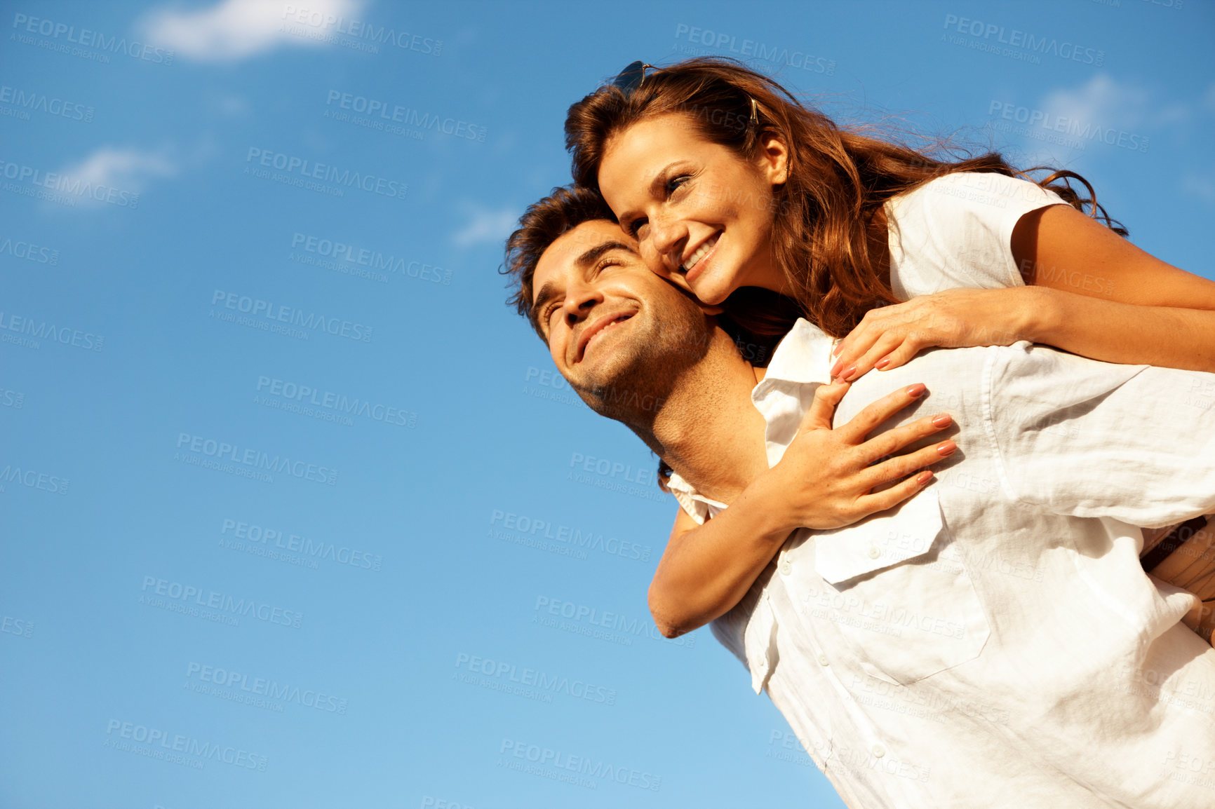 Buy stock photo Love, piggyback and happy couple with blue sky for outdoor holiday or vacation together in nature. Low angle, man or carrying woman with smile or embrace for romance, date or weekend getaway on space
