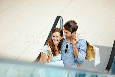 Buy stock photo Date, shopping and escalator with couple in mall for retail purchase, anniversary gift and support. Store discount, customer promotion and love with man and woman with bags for boutique shopper
