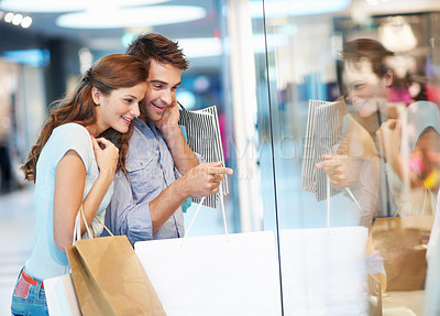 Buy stock photo Couple, window shopping and point with paper bag in mall, love or sale choice with partner on break. Boutique, glass and happy people with purchase decision, search and bonding with customer discount