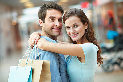 Buy stock photo Hug, portrait and happy couple with shopping bag for payment, purchase or support in mall together. Man, woman or smile with embrace, gifts or relationship in commercial center for retail service