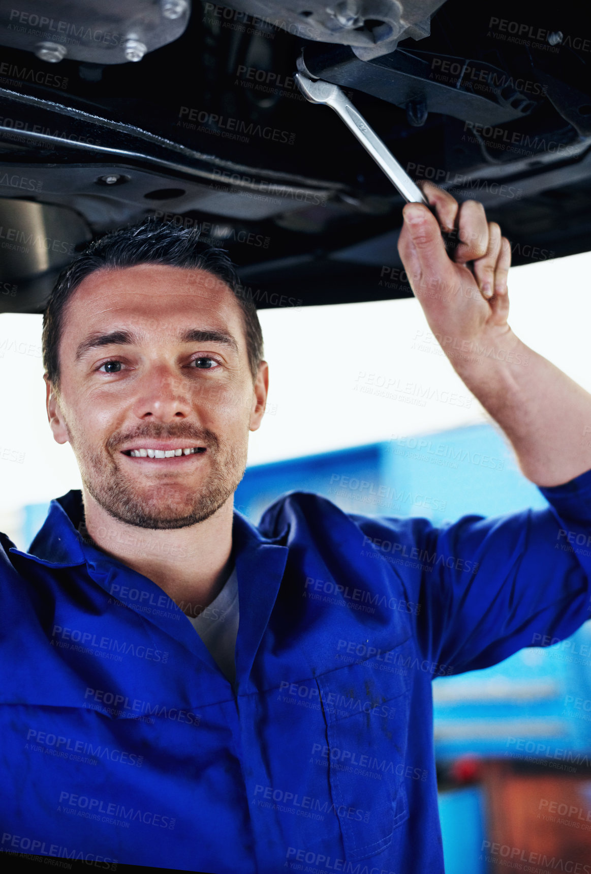 Buy stock photo Car, mechanic and smile with man in garage for automobile maintenance, repair or service. Industry, portrait and undercarriage with happy engineer in vehicle workshop for professional inspection