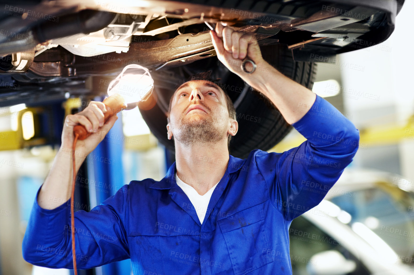 Buy stock photo Car, lamp and maintenance with man in garage for vehicle inspection, repair or service. Light, tool and undercarriage with mechanic in automobile workshop for check, compliance or engineering job