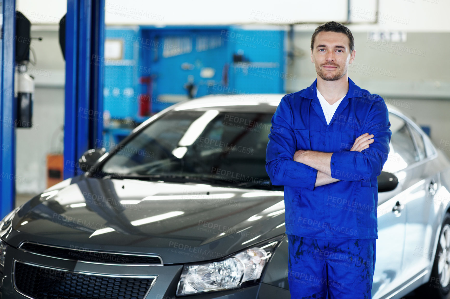 Buy stock photo Man, mechanic and arms crossed with car at garage in portrait for job, inspection or repair service. Person, technician or engineer with vehicle, confidence or career for maintenance in auto workshop