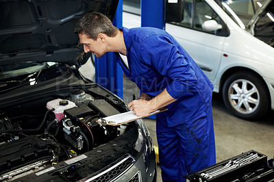 Buy stock photo Man, mechanic and writing on clipboard for vehicle at workshop for notes, inspection or repair services. Person, technician or engineer with car, checklist and maintenance with career at auto garage