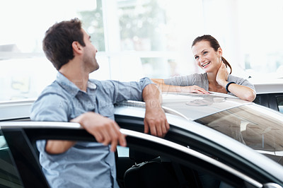 Buy stock photo Couple, talking and happy at car dealership with choice for purchase, buying and decision for vehicle. Man, woman and smile by door for rental option, insurance or showroom for customer or client
