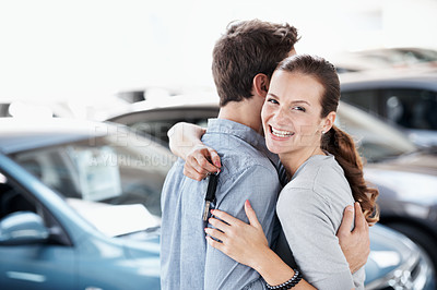 Buy stock photo Portrait, hug and happy couple in showroom with car keys, investment and gratitude for purchase. Excited, woman and married people embrace in dealership with new vehicle, sale or thankful for partner