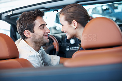 Buy stock photo Car dealership, choice and couple in convertible for decision, purchase or test drive. Back, love and satisfaction with happy people in showroom vehicle for consumerism, insurance or finance