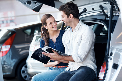 Buy stock photo Option, car or couple at dealership with brochure, review guide or automobile choice in showroom. Smile, relationship or people with leaflet, selection together or purchase info in vehicle evaluation