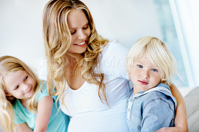 Buy stock photo Portrait of a pregnant mother with her little son and daughter sitting together at home