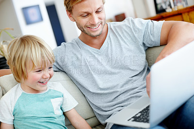 Buy stock photo Handsome dad and his cute son enjoying playing on their laptop at home