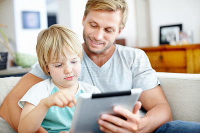 Buy stock photo Loving dad teaching his cute little son to use their new digital tablet