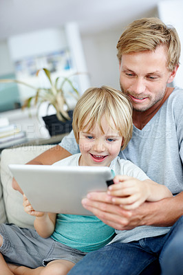 Buy stock photo Loving dad teaching his cute little son to use their new digital tablet