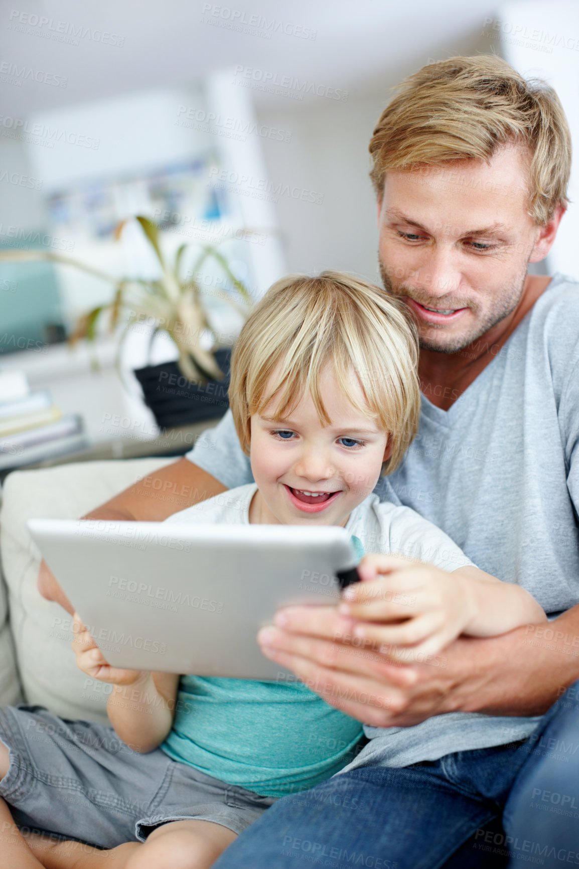 Buy stock photo Loving dad teaching his cute little son to use their new digital tablet