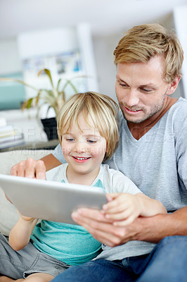 Buy stock photo Handsome dad teaching his cute little son to use their new digital tablet