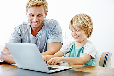 Buy stock photo A young father helping his son on his laptop