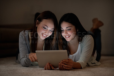 Buy stock photo Two beautiful teenage girls sharing a digital tablet