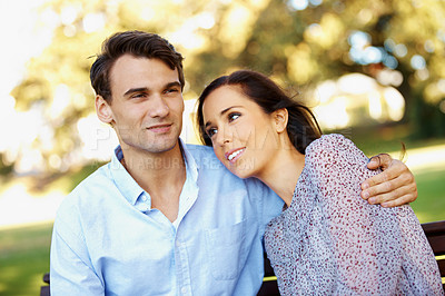Buy stock photo Handsome young man looking away pensively with his beautiful girlfriend beside him in a sunny park