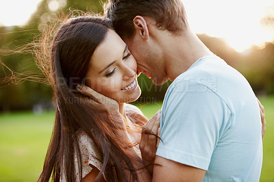 Buy stock photo Closeup of a beautiful woman being embraced by her boyfriend in a park