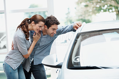 Buy stock photo Hug, happy couple and shopping at car dealership, check and decision for automobile with support. Showroom, man and woman with vehicle inspection for purchase, embrace and customers with transport