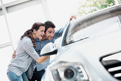 Buy stock photo Dealership, smile and couple with car inspection, discussion and choice for automobile with partner. Showroom, man and woman with dream vehicle for shopping, hug or happy customers with transport