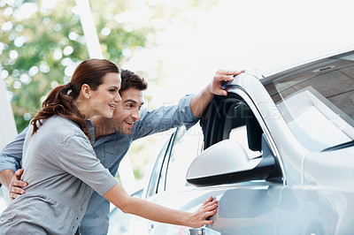 Buy stock photo Car, choice and shopping with couple in dealership together for decision or purchase. Checking, retail and sale with happy people on showroom floor for consumerism, insurance or vehicle finance