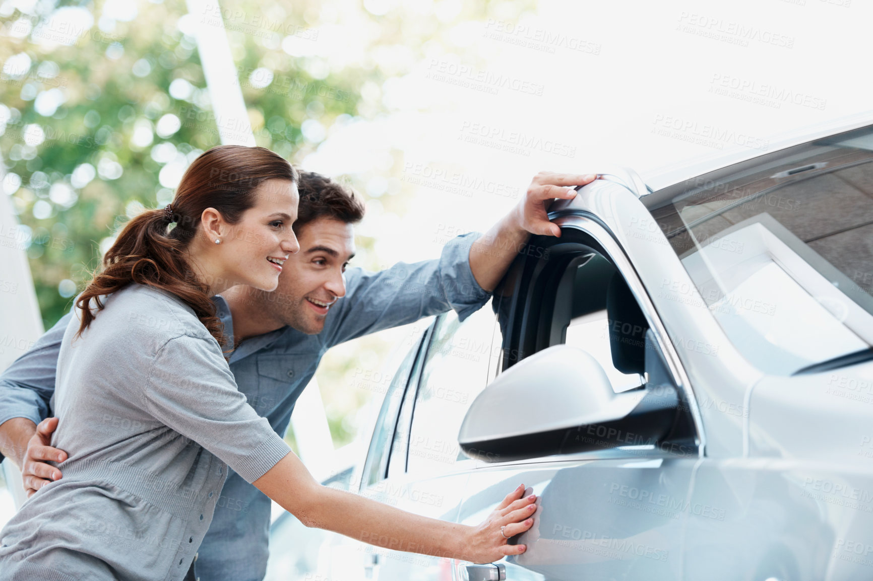 Buy stock photo Car, choice and shopping with couple in dealership together for decision or purchase. Checking, retail and sale with happy people on showroom floor for consumerism, insurance or vehicle finance