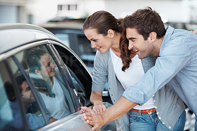Buy stock photo Car, choice and shopping with happy couple in dealership together for decision or purchase. Buying, retail sale and satisfaction with people in showroom for consumerism, insurance or vehicle finance