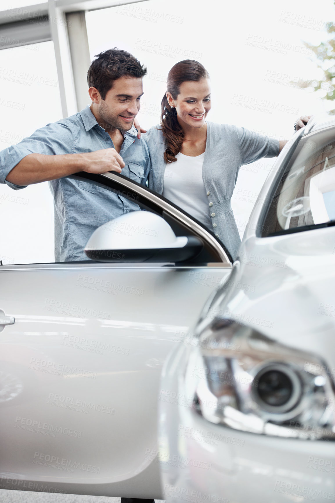 Buy stock photo Smile, couple and shopping at car dealership, inspection and decision for automobile with partner. Showroom, man and woman check vehicle for purchase evaluation, rental and transport with customers