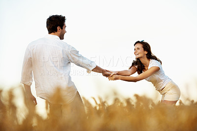 Buy stock photo Couple, holding hands and happy outdoor in meadow on date, partner and support with fun in nature. People, marriage and playful for healthy relationship, bonding and together with smile for love