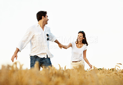 Buy stock photo Smile, couple and holding hands in wheat field for vacation, bonding or romance in countryside. Happy, man and woman in nature for weekend trip together with holiday, anniversary and playful travel