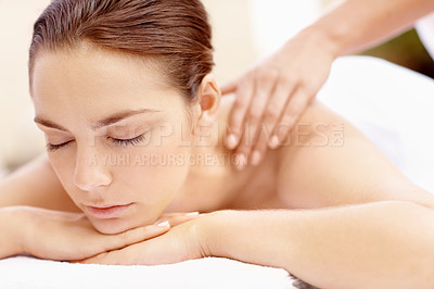 Buy stock photo Relaxed young woman lying on a spa bed with her eyes closed and receiving a massage
