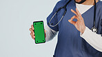 Nurse, phone and hands with green screen in studio for marketing app on a white background. Person, healthcare worker or showing mockup space with like emoji or OK sign for advertising or good review