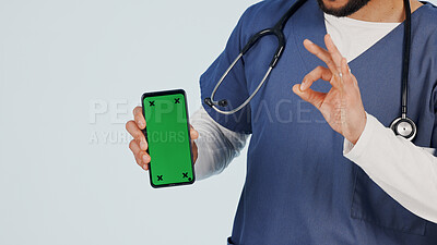 Buy stock photo Nurse, phone and hands with green screen in studio for marketing app on a white background. Person, healthcare worker or showing mockup space with like emoji or OK sign for advertising or good review
