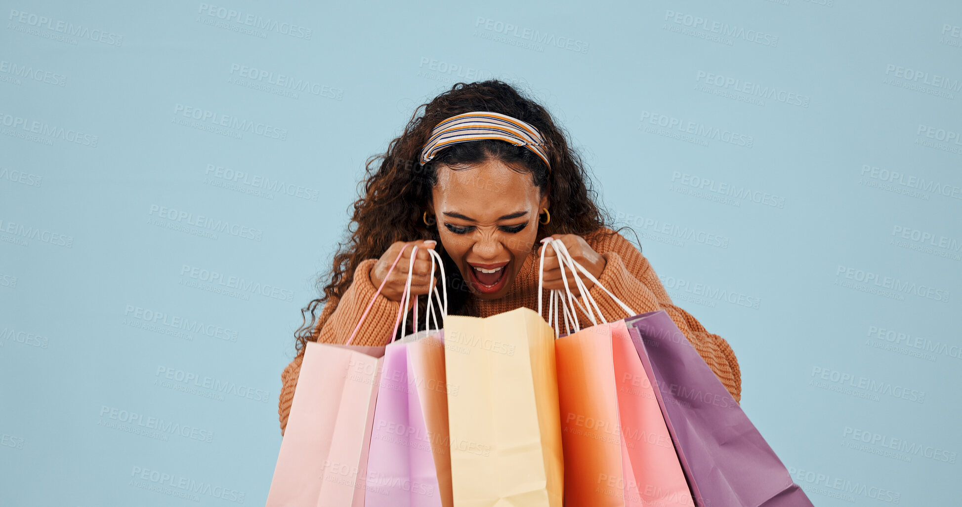 Buy stock photo Shopping bags, shock or woman in studio with purchase, promo deal or retail discount on weekend break. Surprise, space or person with paper carrier, fashion bargain or apparel sale on blue background