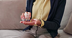 Woman, hands and pills with container in home for medical treatment, cure or recovery on sofa. Female person, patient or tablets with prescription for healthcare, diagnosis or clinic care in house