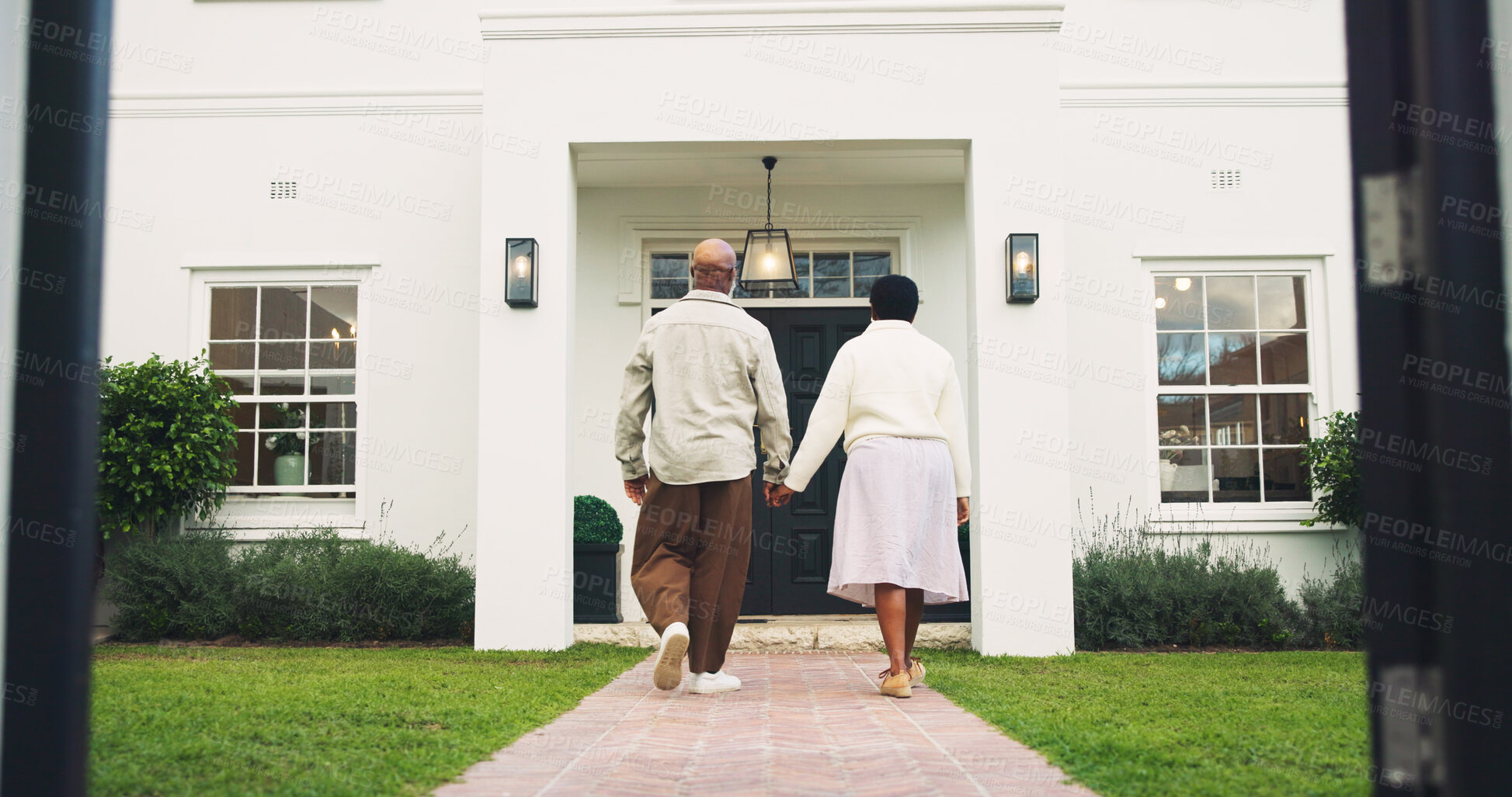 Buy stock photo Couple, walk and holding hands in front yard with new home, property investment and real estate goals. Back, African people and moving in house with relocation, mortgage loan and support together