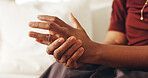 Arthritis, hand and massage with person in home living room for joint pain, stiffness or swelling. Disease, fibromyalgia or osteoporosis with elderly woman on sofa in apartment for health condition
