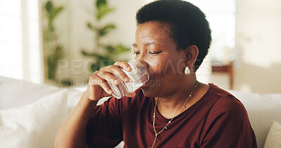 Buy stock photo Drinking, water and black woman on sofa in home with health, wellness or digestion support. Hydration, thirst and mature person with glass of cold beverage or mineral liquid for detox in living room.