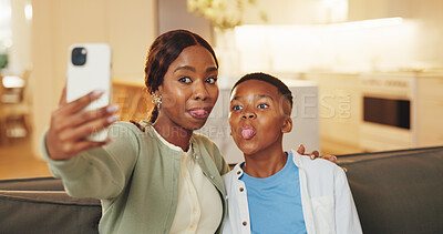 Buy stock photo Mom, selfie and son with tongue out on sofa in home living room for bonding, memories or social media. Black family, funny face and love with woman hugging boy child for photograph or profile picture