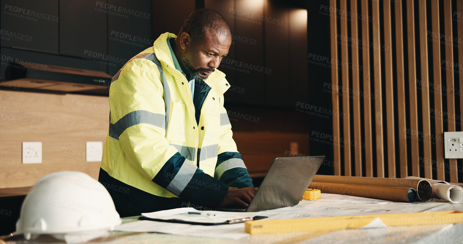Buy stock photo Architect, man and typing in home with laptop, renovation research or planning for property upgrade. Mature, black person and computer in house for architecture, check layout and remodeling project.