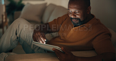 Buy stock photo Tablet, scrolling and black man in home at night for reading blog on budget, savings and investment planning. Digital technology, relax and mature person on app for financial tips, advice or guidance