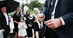 Man, hand and rose in cemetery with funeral, people mourning and burial ceremony for final goodbye. Person, flower and family death in graveyard outdoor with memorial service, grief and bereavement.