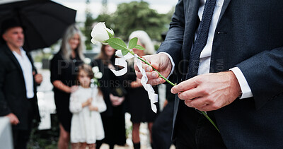 Buy stock photo Man, hand and rose in cemetery with funeral, people mourning and burial ceremony for final goodbye. Person, flower and family death in graveyard outdoor with memorial service, grief and bereavement.