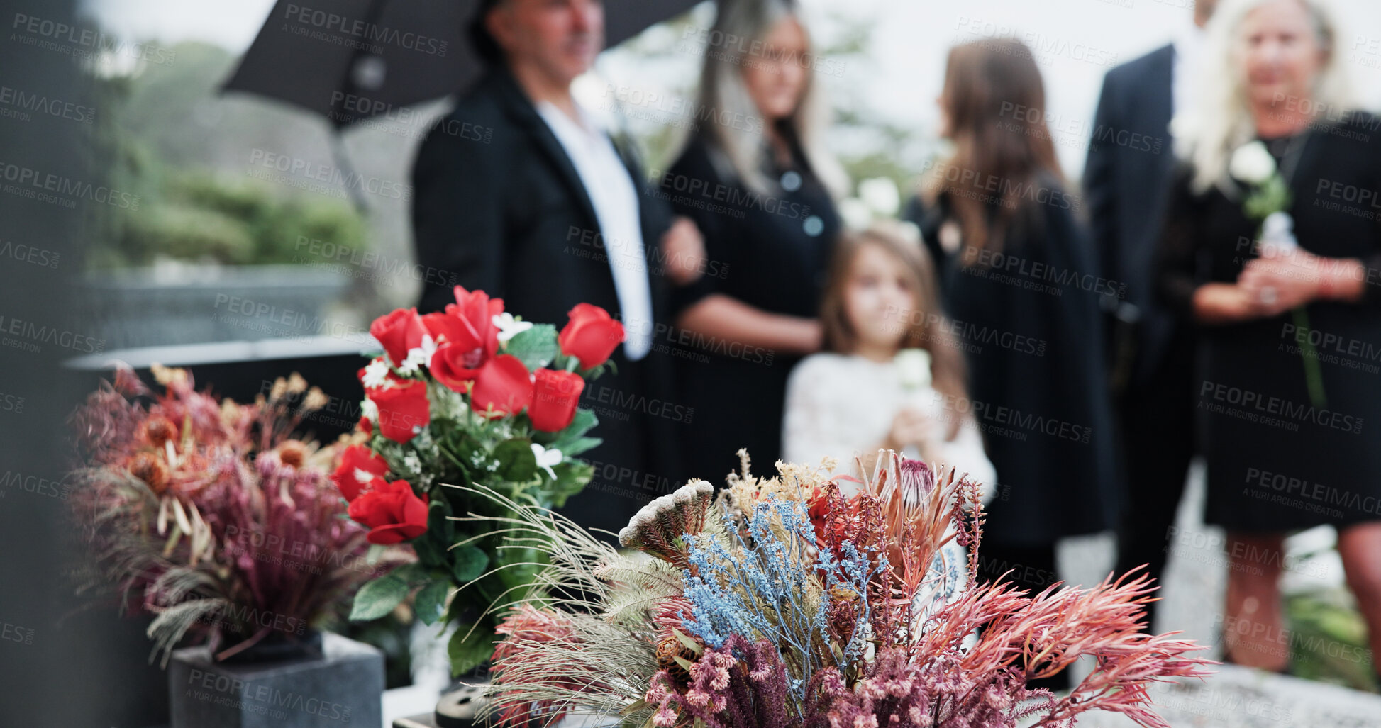 Buy stock photo Flowers, sad and people in cemetery, support for grief and compassion with burial for death ceremony. Family, memorial service and group in graveyard, mourning loss and crying with respect or emotion