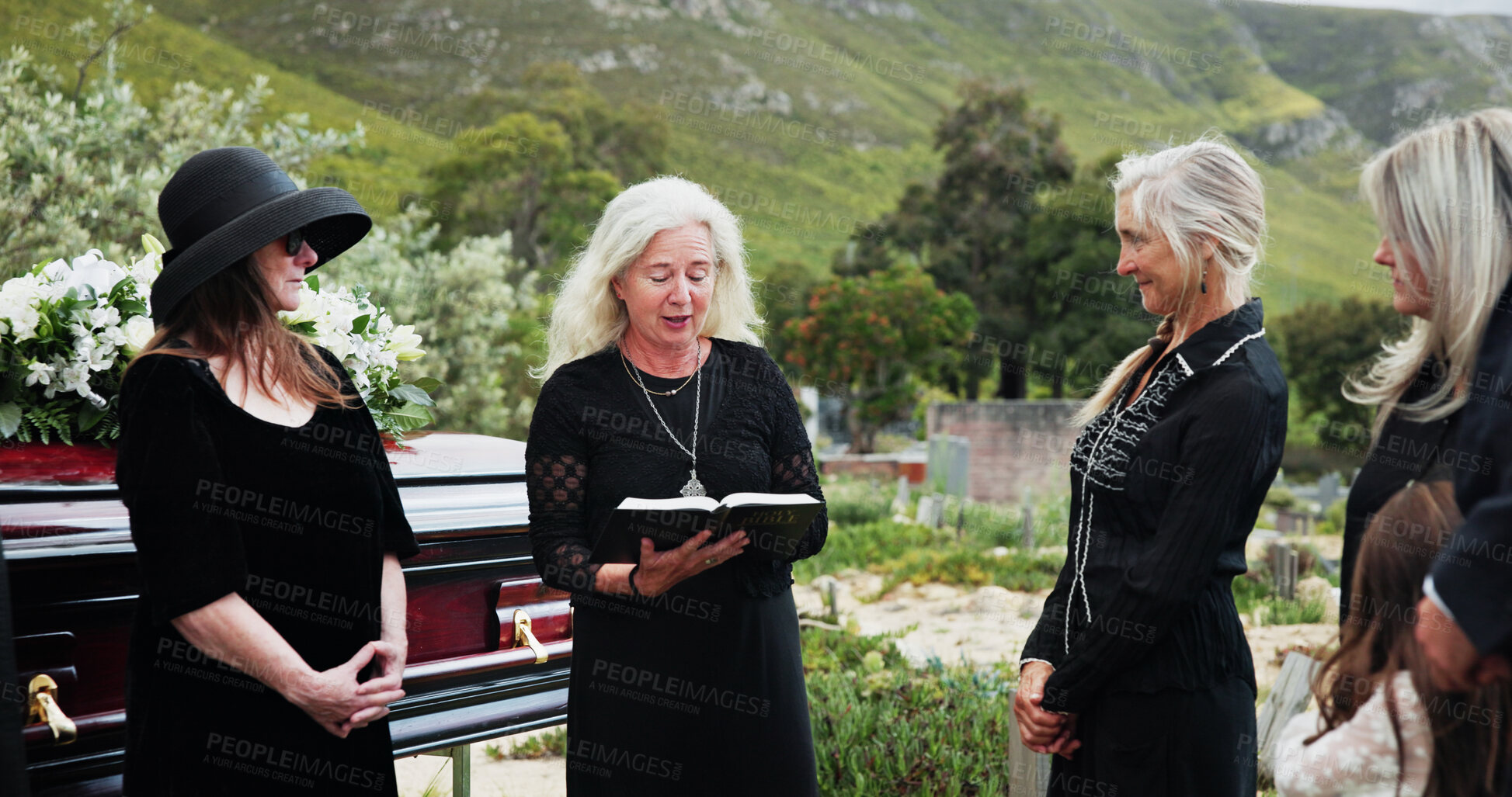 Buy stock photo Funeral, old women and pastor with bible at graveyard, religion and memorial service with community. Christian, faith and elderly person with scripture for burial, prayer and ceremony with family