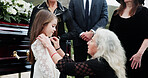 Sad, grandmother and child in graveyard with funeral, people mourning and support for burial ceremony. Senior woman, girl and family death at cemetery outdoor with memorial service, empathy and care.
