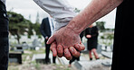 Funeral, people and holding hands in graveyard with grief, mourning and empathy for burial ceremony. Family, death and senior person at cemetery outdoor with memorial service, bereavement or support.